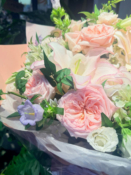 淡粉玫瑰與 ivory lilies 組成的 sympathy bouquet close-up