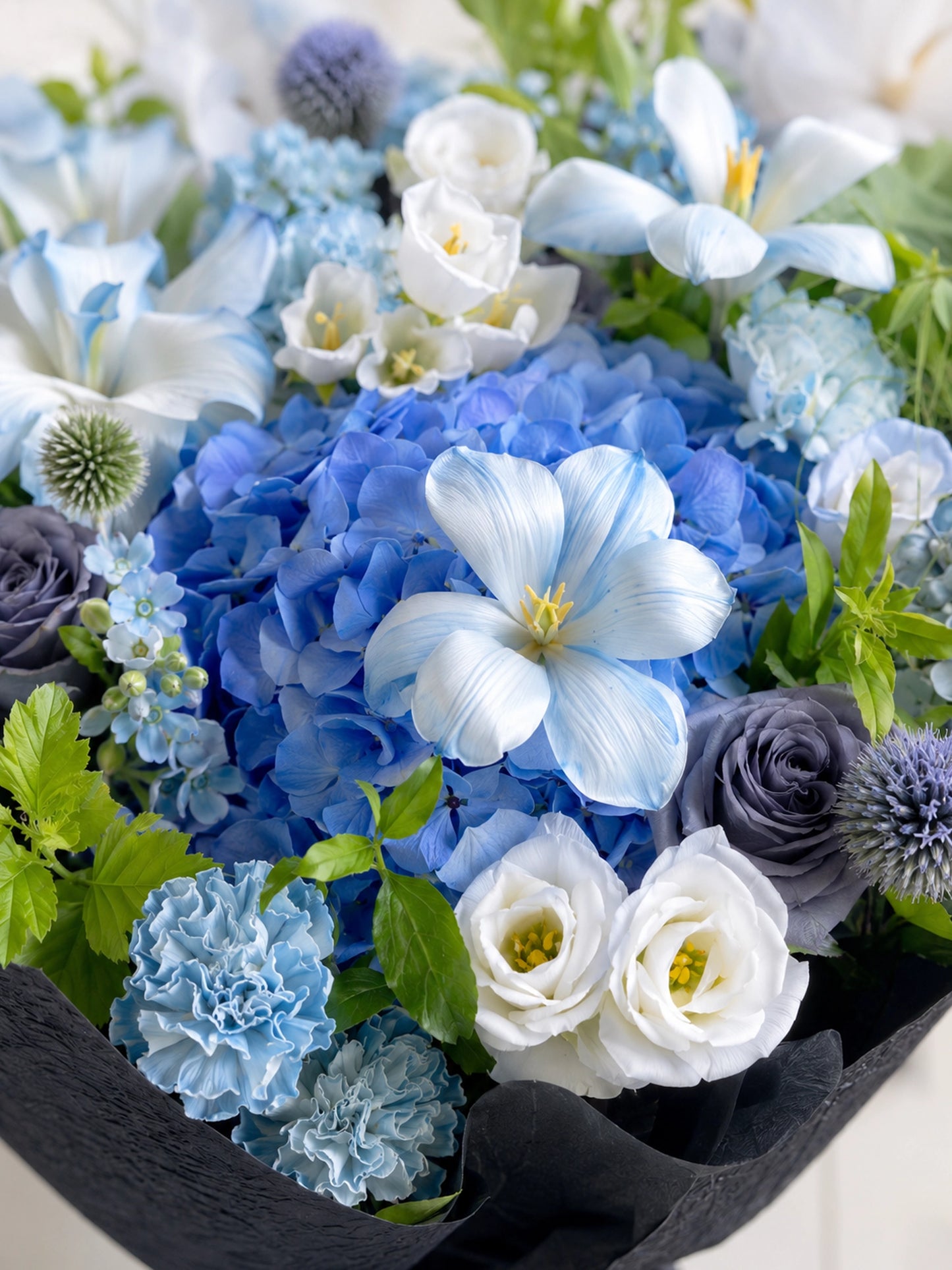 Midnight Voyage close-up，展示藍色繡球、淡藍 clematis、白色 lisianthus 及灰藍玫瑰