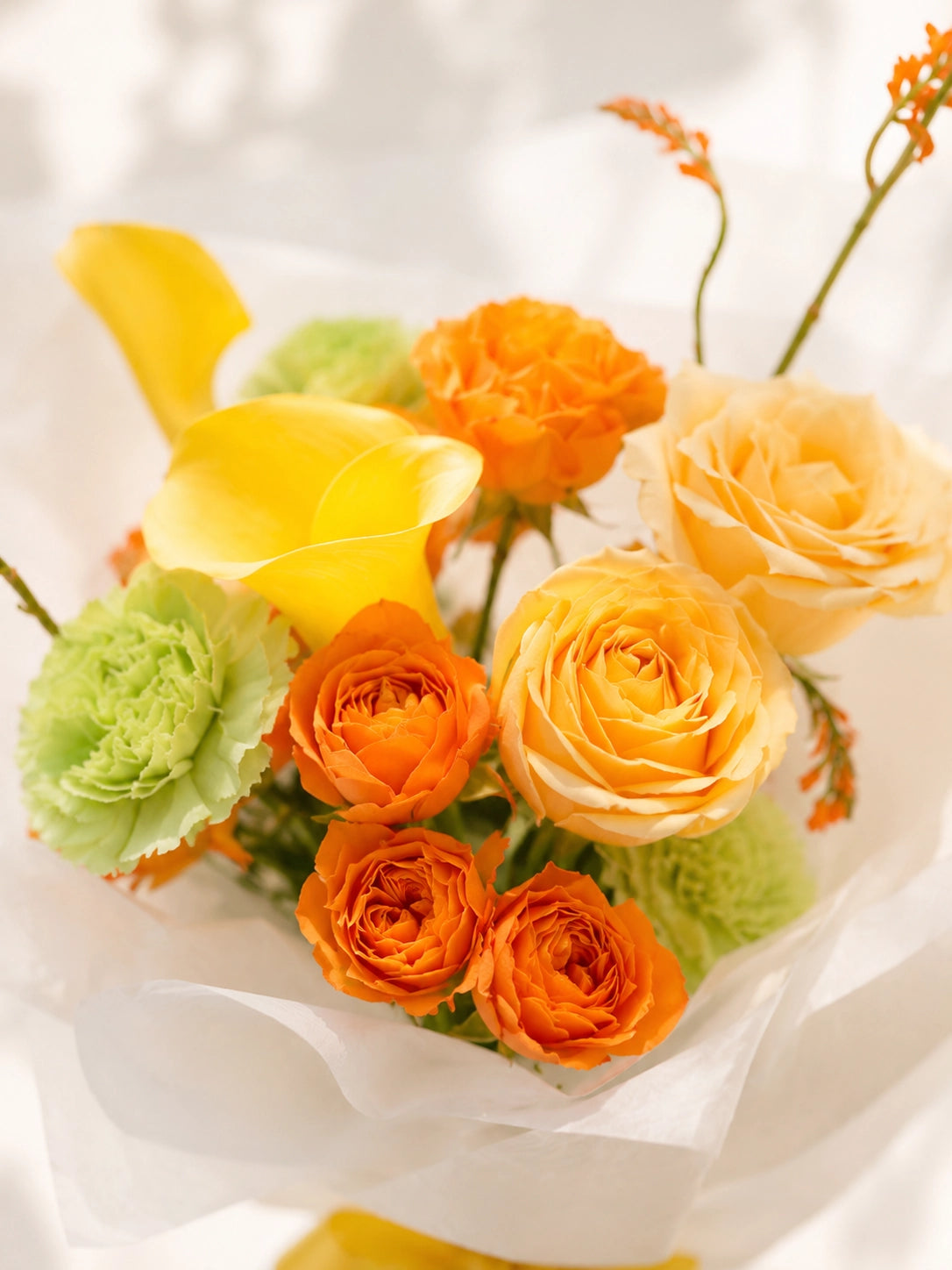 After Our First Goodbye 側角特寫，香檳玫瑰、黃色 calla lilies 同橙色花材自然交織，warm floral arrangement celebrating reunion and joyful moments.