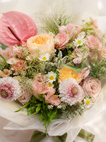 All You Need To Know 側角特寫，粉色花材層次自然交織，romantic bouquet with roses, gerberas and seasonal blooms.