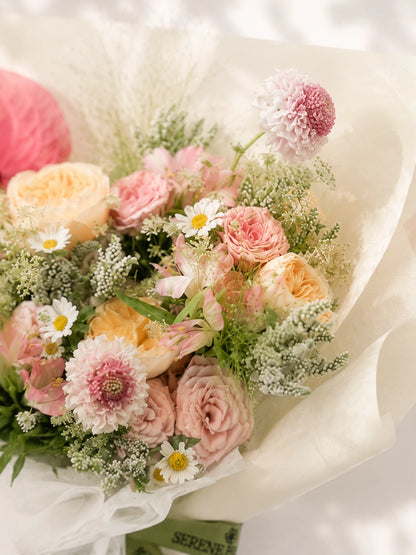 All You Need To Know close-up，柔粉玫瑰、Gerberas 同粉紅 Anthurium 花材細節，soft pastel floral arrangement with elegant texture.