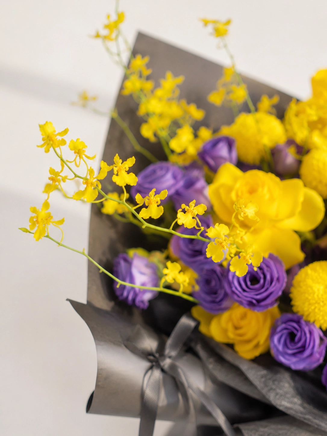 Dimple Bloom 側角特寫，黃色玫瑰、紫色 Lisianthus 同季節花材自然交織，vibrant bouquet full of warmth and sweet smiles.