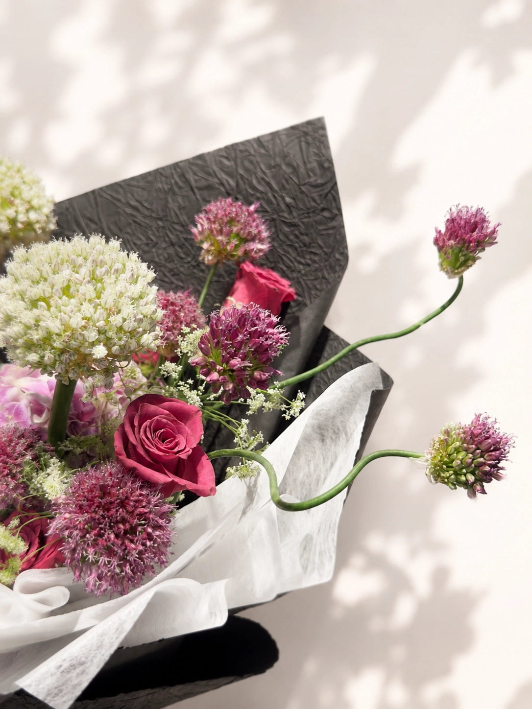 Midnight Reverie bouquet 側面特寫, lavender hydrangea 配紫紅玫瑰及 allium, elegant black wrapped bouquet