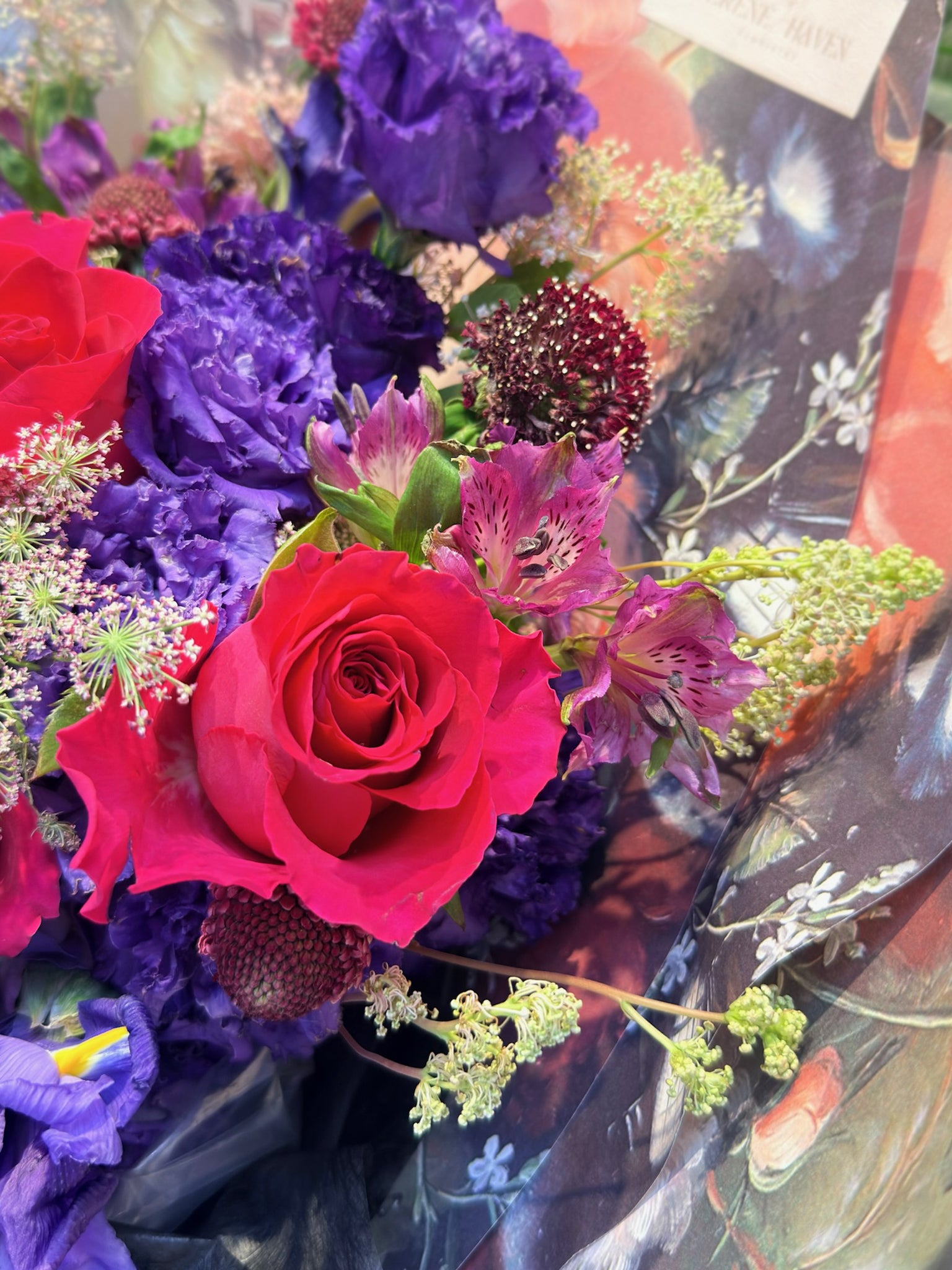 Red roses 與 violet flowers 特寫，luxury floral arrangement