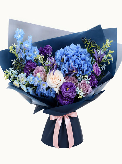 Nocturne Embrace 藍紫色花束主圖，配搭 blue hydrangea、mauve roses、lisianthus 及深藍包裝