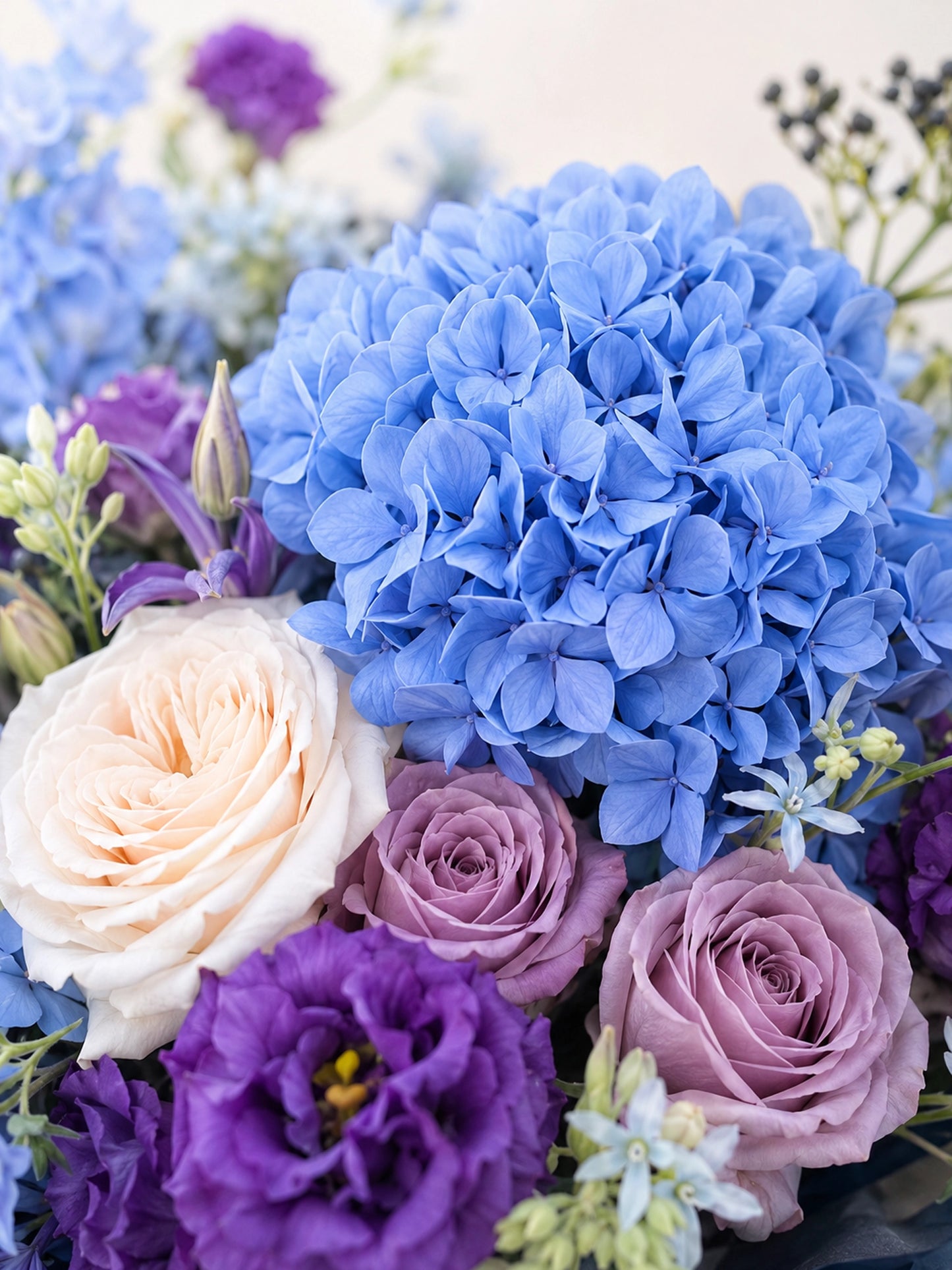 Nocturne Embrace close-up，展示藍色繡球、紫色 lisianthus、裸粉玫瑰及白玫瑰細節
