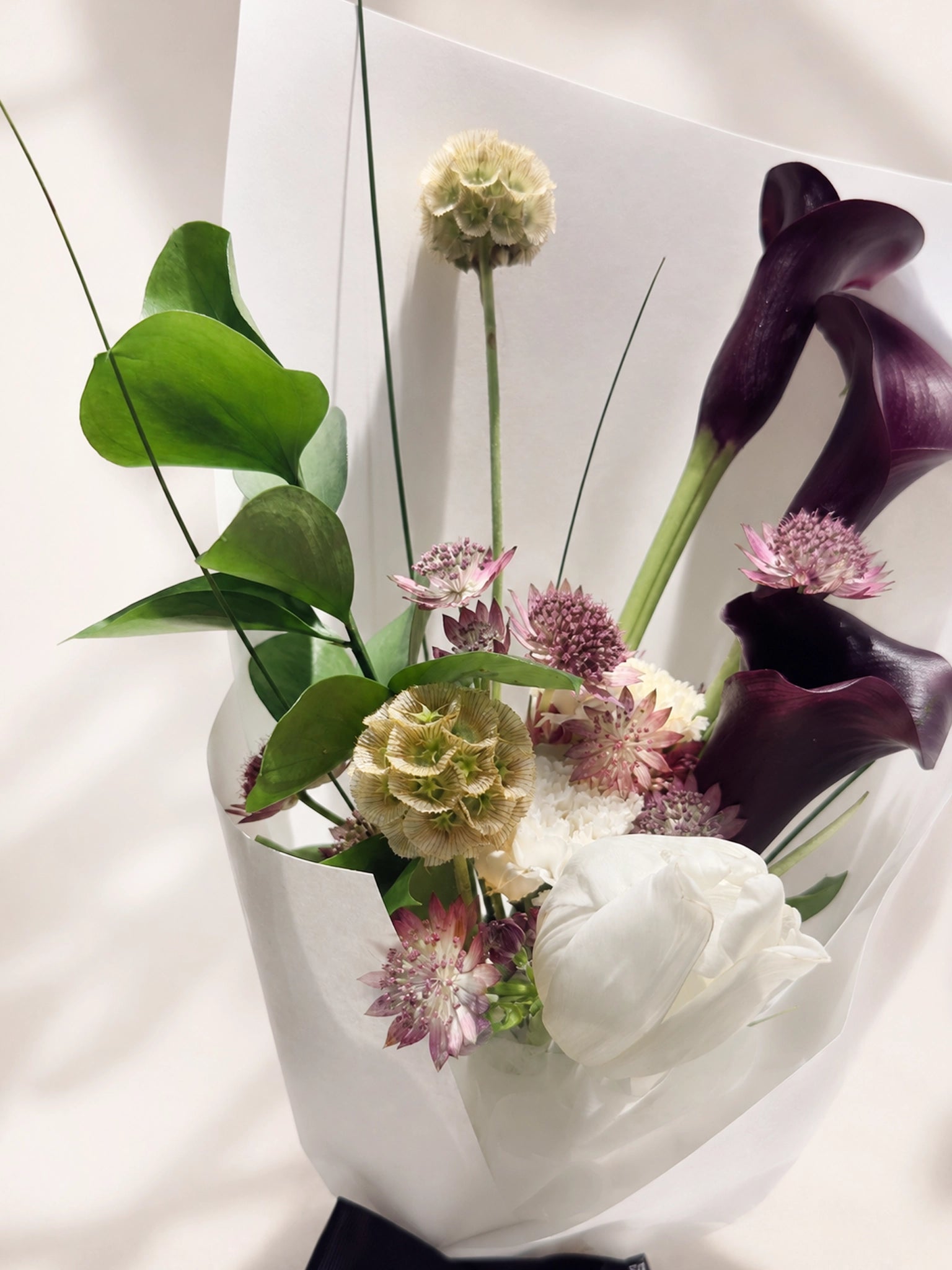 Obsidian Grace bouquet 細節，深紫黑色馬蹄蘭與綠葉 close-up，充滿雕塑感與現代美學。