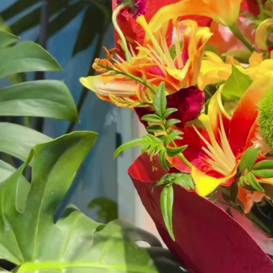 Amber Flame bouquet 360° video，展示鮮橙 lilies、雞冠花及酒紅包裝，多角度欣賞 vibrant floral arrangement inspired by golden sunsets.