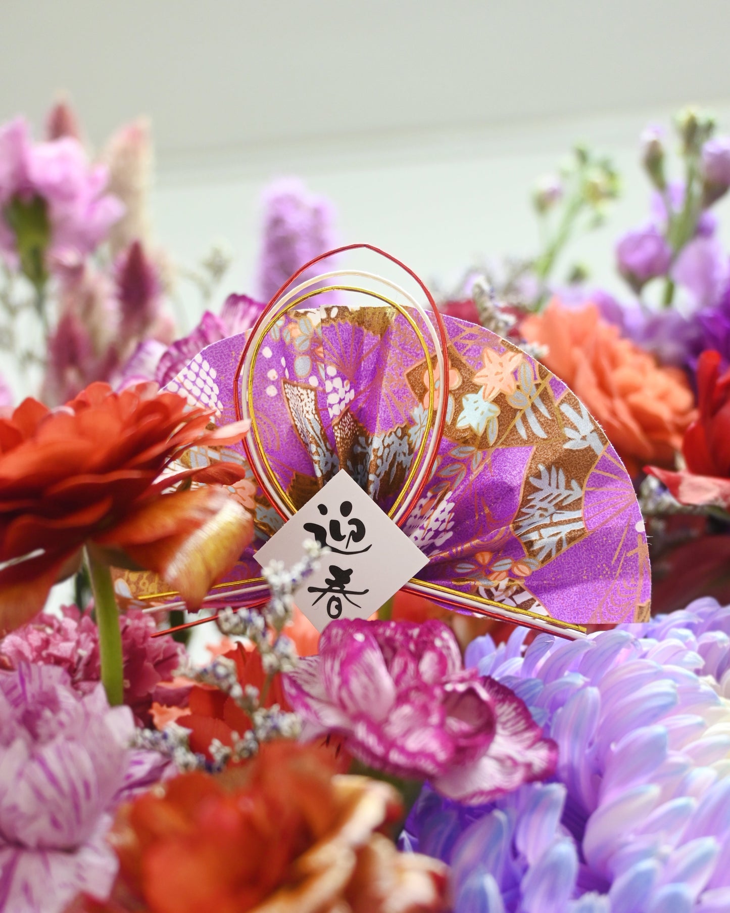紫紅花材 close-up，配 gold decorative accent、ribbon 及 gift tag