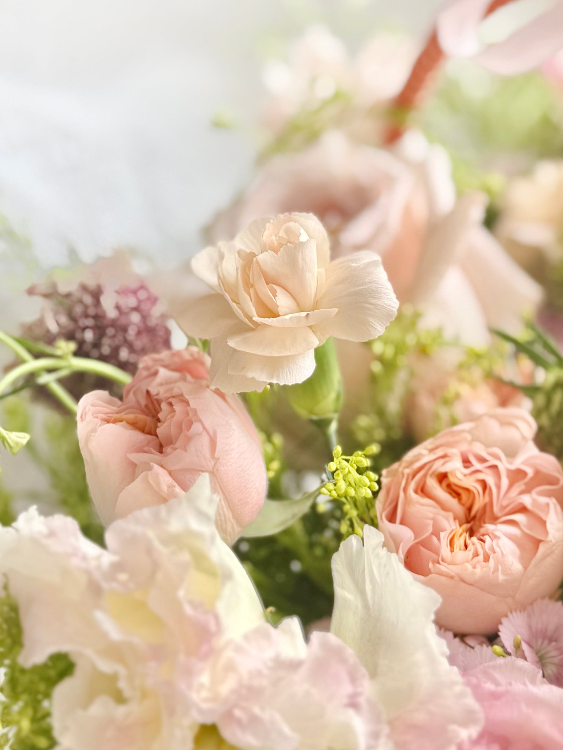 Quiet Comfort Basket 象牙白花朵與淡粉季節花材 close-up