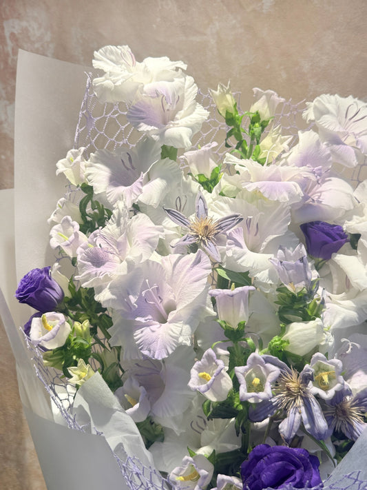 白色花朵配淡紫色 seasonal blooms 的 remembrance bouquet close-up