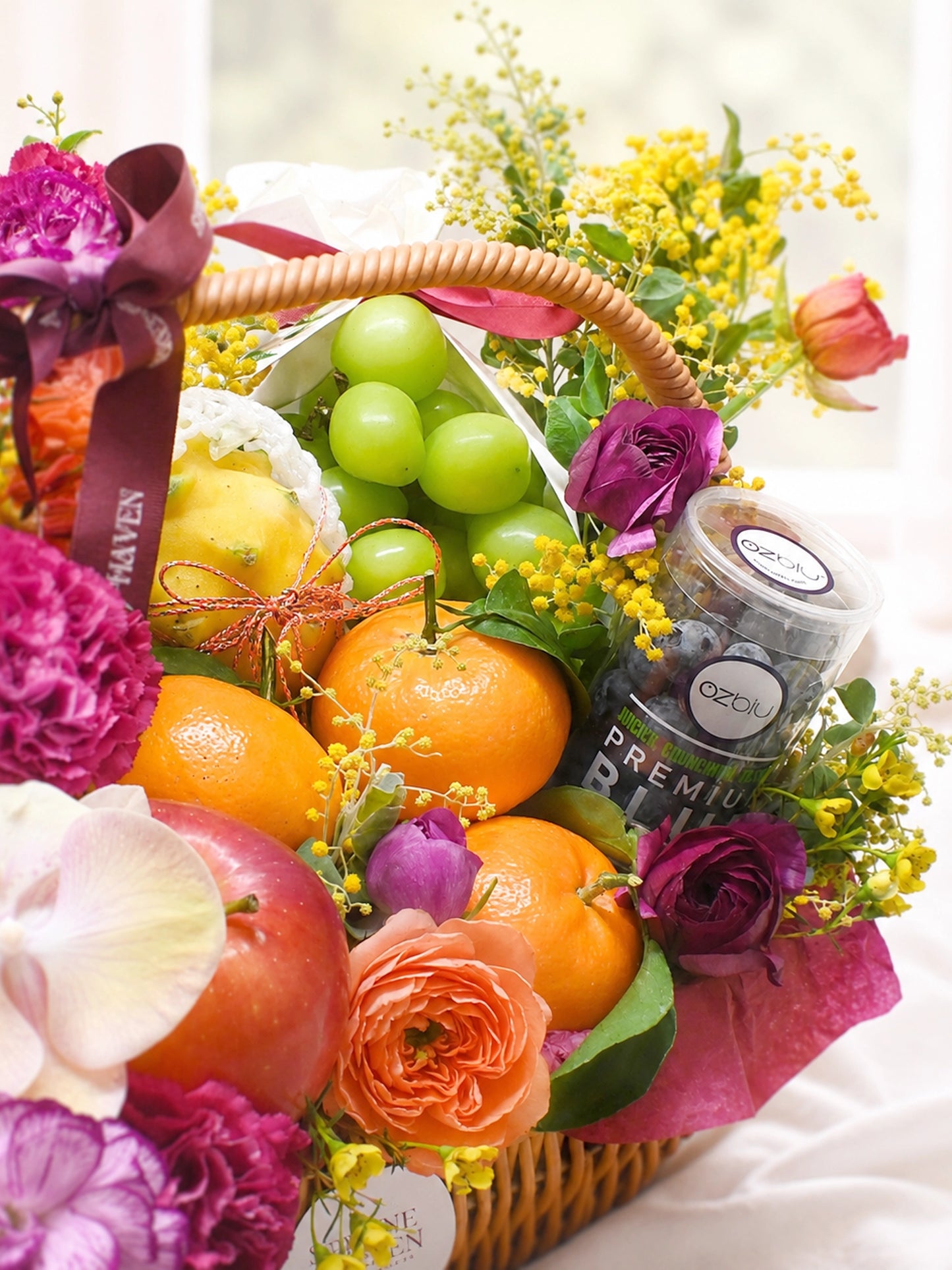 Serene Haven Wellness 禮籃細節，新鮮水果及花藝近拍。Close-up of fresh fruits and floral arrangement.
