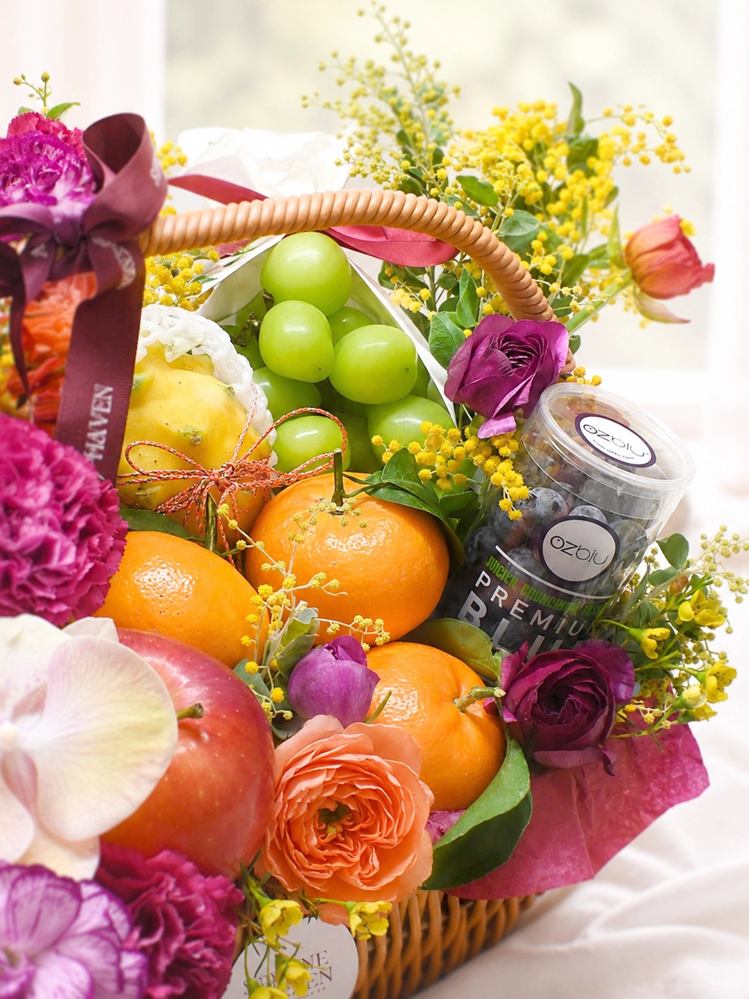 Serene Haven Wellness 禮籃細節，新鮮水果及花藝近拍。Close-up of fresh fruits and floral arrangement.
