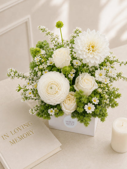 White Remembrance Table Arrangement 擺放於室內紀念空間，elegant white sympathy flowers creating a peaceful and comforting atmosphere